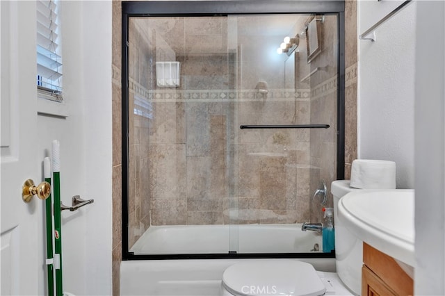 full bathroom featuring shower / bath combination with glass door, vanity, and toilet