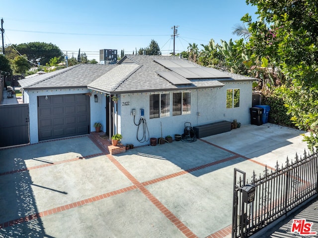 view of front of property featuring a garage and central AC