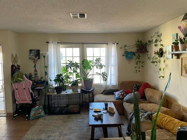 sitting room with a textured ceiling and tile patterned floors