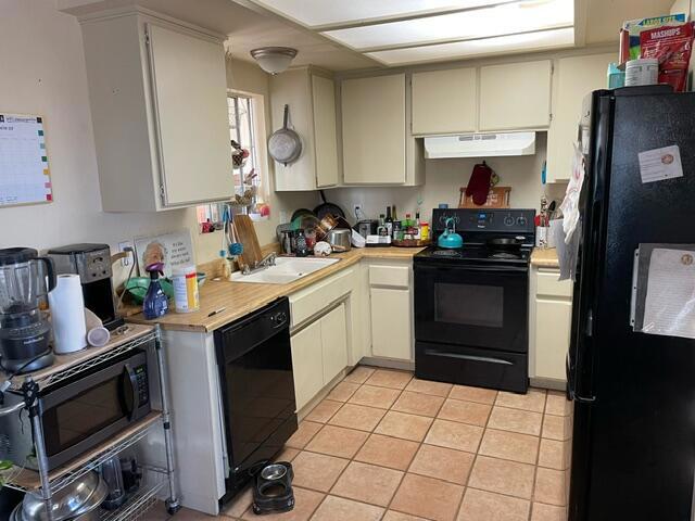 kitchen featuring light tile patterned flooring, sink, and black appliances