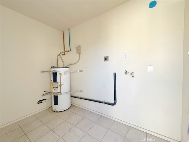 laundry area with electric water heater, electric dryer hookup, and light tile patterned floors