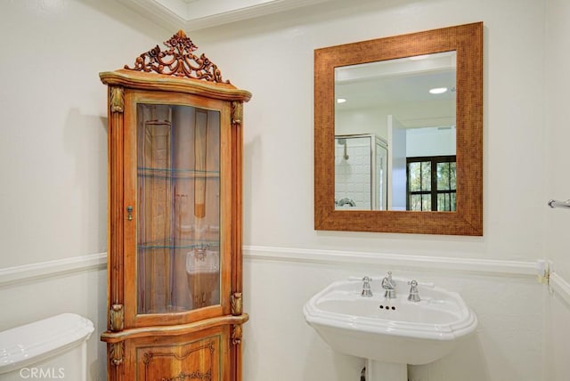 bathroom featuring sink, toilet, and ornamental molding