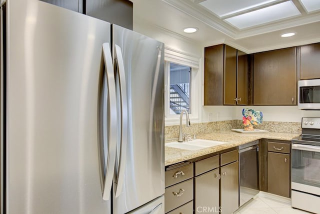 kitchen featuring appliances with stainless steel finishes, sink, ornamental molding, light stone counters, and dark brown cabinets