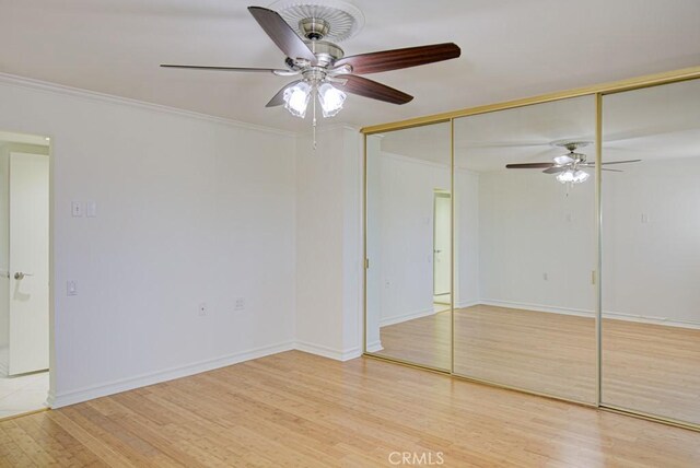 unfurnished bedroom with a closet, ceiling fan, light hardwood / wood-style flooring, and crown molding