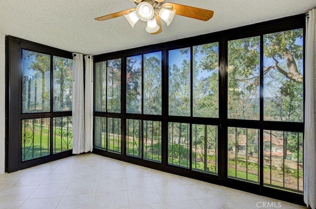 unfurnished sunroom with ceiling fan