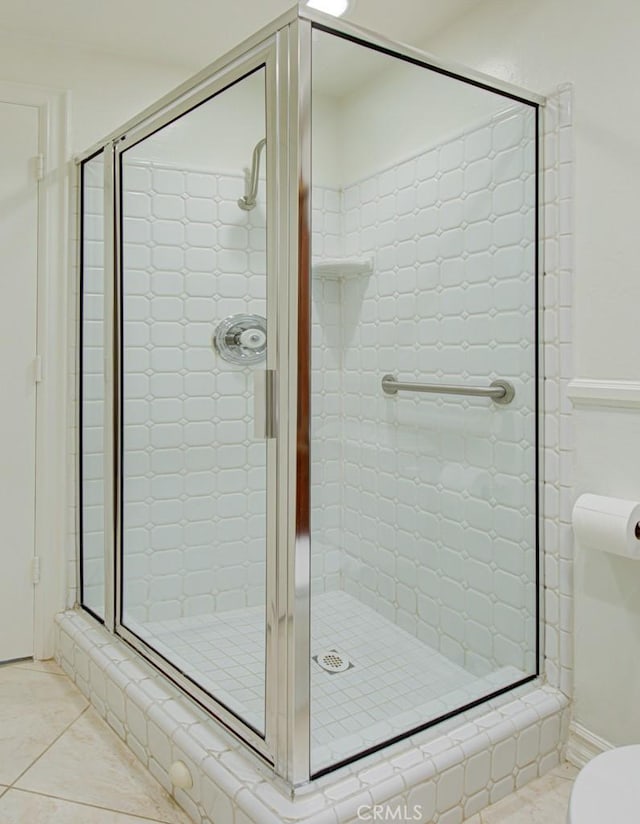 bathroom with toilet, tile patterned floors, and an enclosed shower