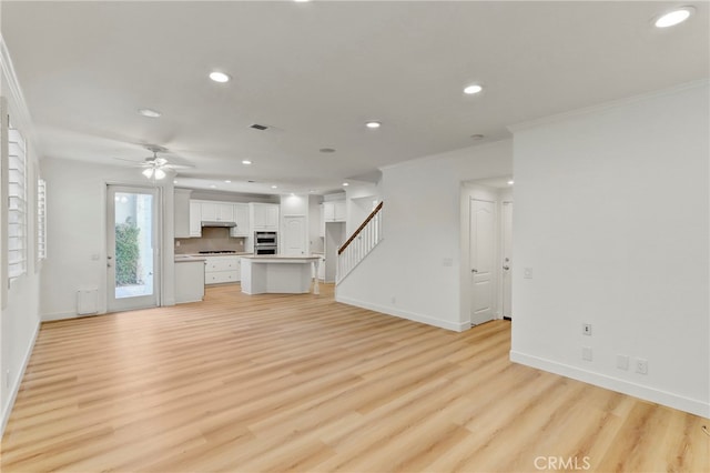 unfurnished living room with ceiling fan, crown molding, and light hardwood / wood-style floors