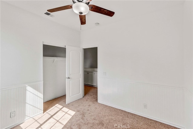 unfurnished bedroom with light carpet, a closet, and ceiling fan