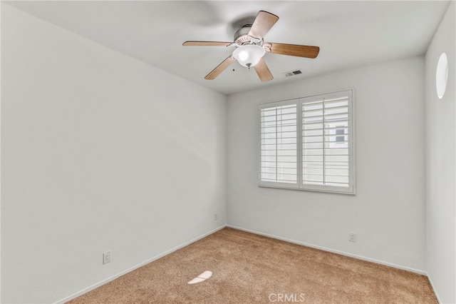 empty room featuring ceiling fan and light carpet