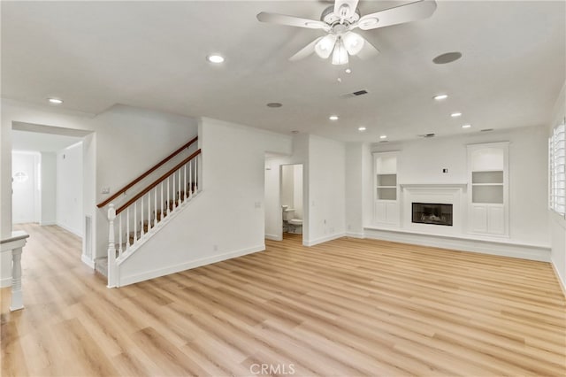 unfurnished living room featuring ceiling fan, light hardwood / wood-style flooring, and built in features