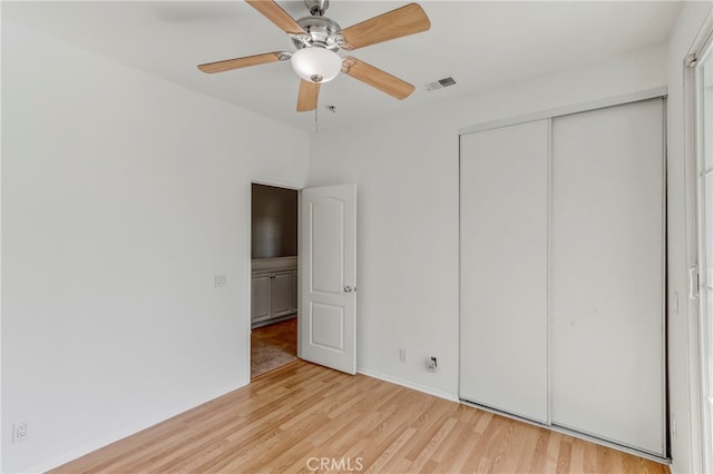 unfurnished bedroom featuring a closet, light hardwood / wood-style floors, and ceiling fan