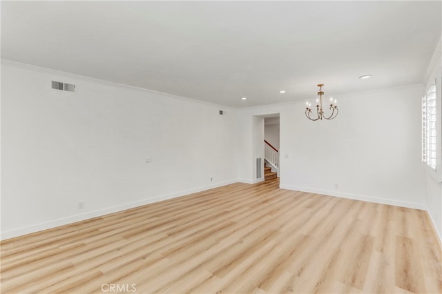 unfurnished room featuring ornamental molding, a chandelier, and light hardwood / wood-style flooring