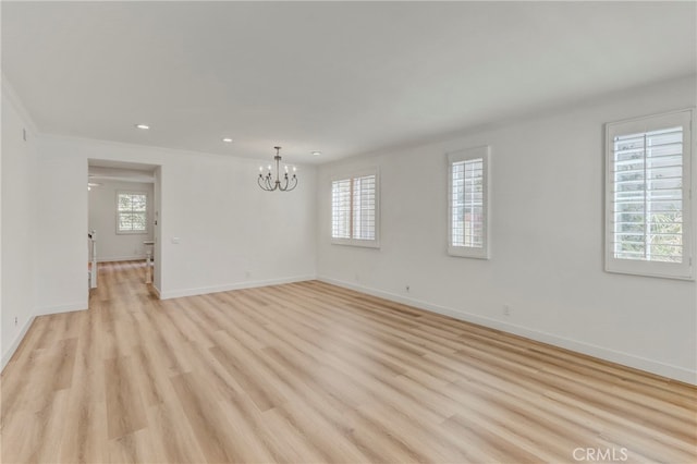 spare room featuring light wood-type flooring and plenty of natural light