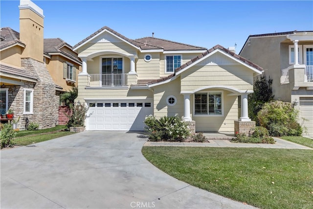 view of front of house with a front yard, a garage, and a balcony