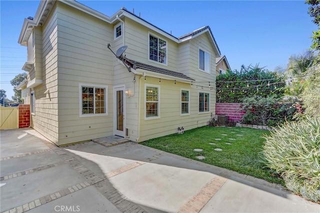 back of house featuring a yard, central AC, and a patio