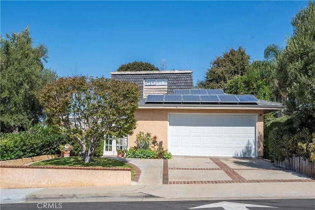 view of front of house featuring solar panels and a garage