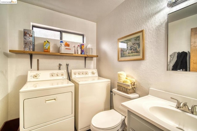 bathroom featuring vanity, toilet, and washing machine and clothes dryer