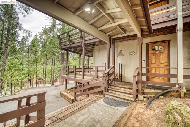 view of exterior entry featuring a deck and a patio area