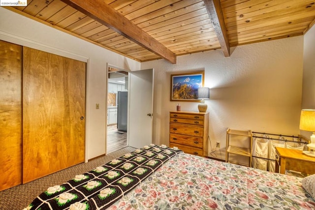 carpeted bedroom featuring wood ceiling, a closet, beamed ceiling, and stainless steel refrigerator