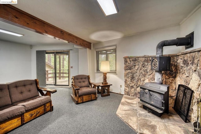 living room featuring carpet floors, crown molding, beam ceiling, and a wood stove