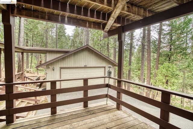 wooden terrace featuring an outdoor structure and a garage