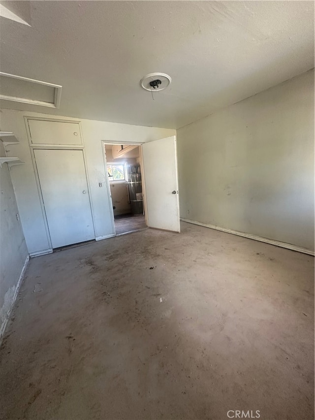 unfurnished bedroom with a textured ceiling and concrete floors