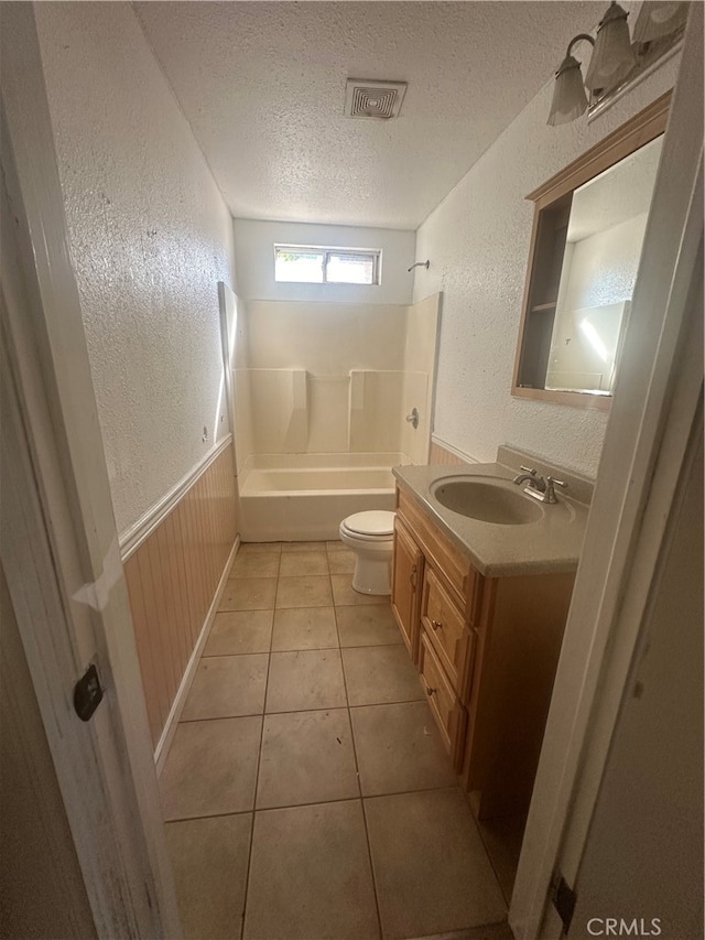 full bathroom featuring vanity, a textured ceiling, bathing tub / shower combination, tile patterned floors, and toilet