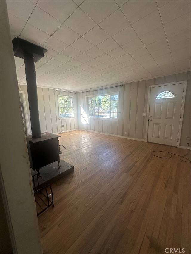 unfurnished living room with wood-type flooring and a wood stove