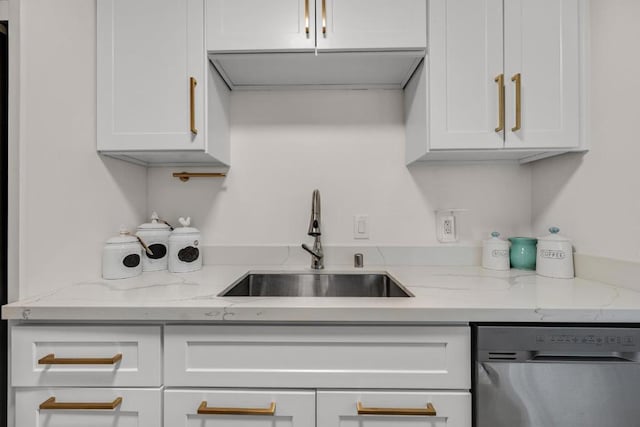 kitchen with light stone counters, sink, white cabinets, and stainless steel dishwasher