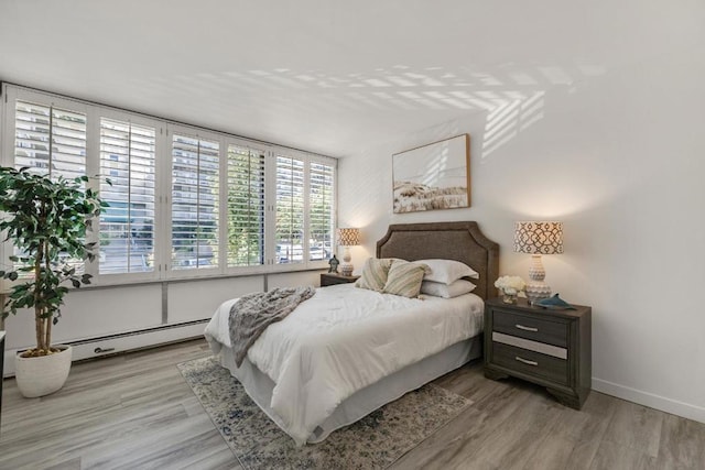 bedroom featuring light wood-type flooring and baseboard heating