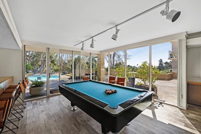 playroom with rail lighting, pool table, hardwood / wood-style flooring, and expansive windows