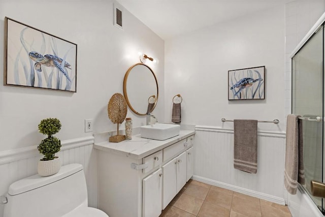 full bathroom featuring bath / shower combo with glass door, tile patterned floors, toilet, and vanity