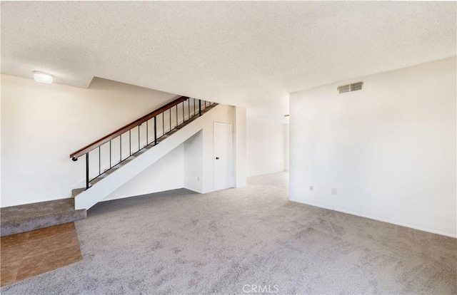 unfurnished living room featuring a textured ceiling and carpet