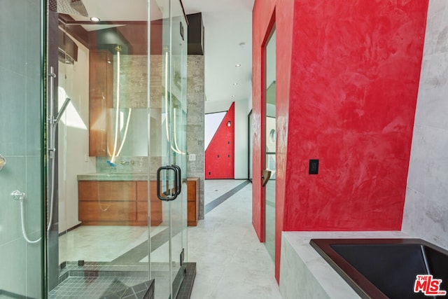 bathroom featuring vanity, plus walk in shower, and tile walls