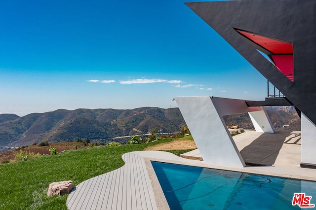 view of swimming pool featuring a patio and a mountain view