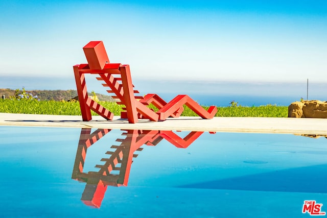 view of swimming pool featuring a water view