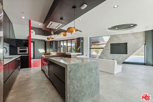 kitchen with a spacious island, pendant lighting, and oven