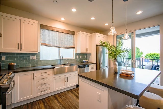 kitchen with a wealth of natural light, white cabinetry, sink, and appliances with stainless steel finishes