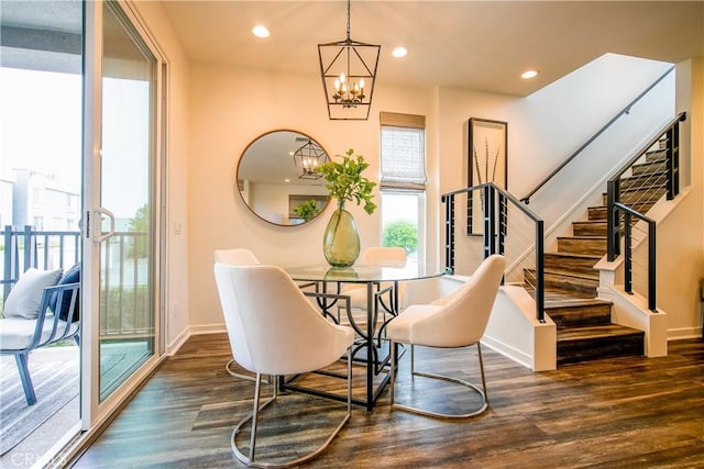 dining space featuring dark hardwood / wood-style floors and an inviting chandelier