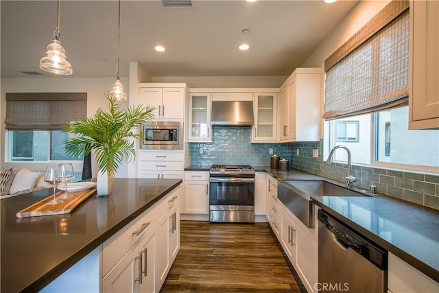 kitchen featuring white cabinets, wall chimney exhaust hood, and stainless steel appliances