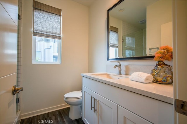 bathroom with hardwood / wood-style floors, vanity, toilet, and an enclosed shower