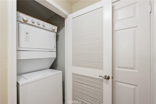 washroom featuring stacked washer / dryer