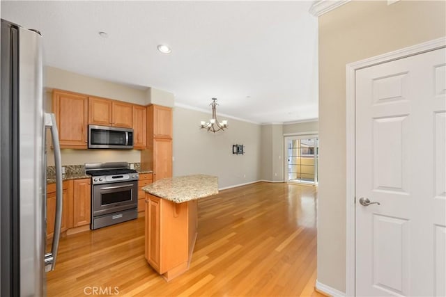 kitchen featuring a chandelier, a center island, stainless steel appliances, and light hardwood / wood-style floors