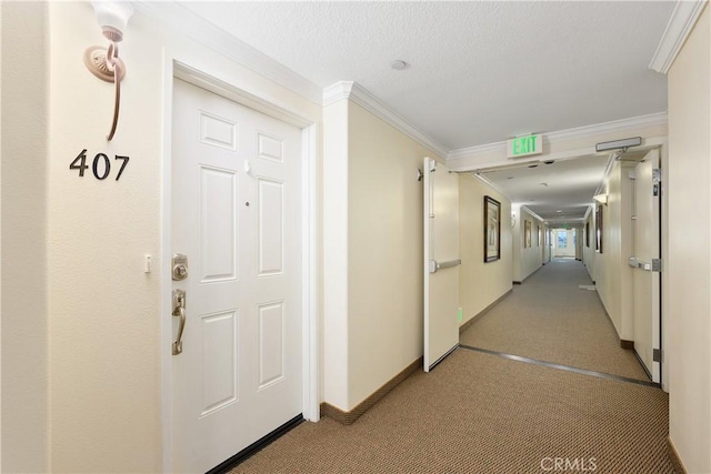 corridor with ornamental molding and a textured ceiling