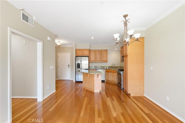 kitchen with sink, a center island, hanging light fixtures, light hardwood / wood-style floors, and appliances with stainless steel finishes