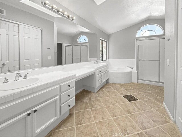 bathroom with plus walk in shower, a textured ceiling, tile patterned floors, vaulted ceiling, and vanity