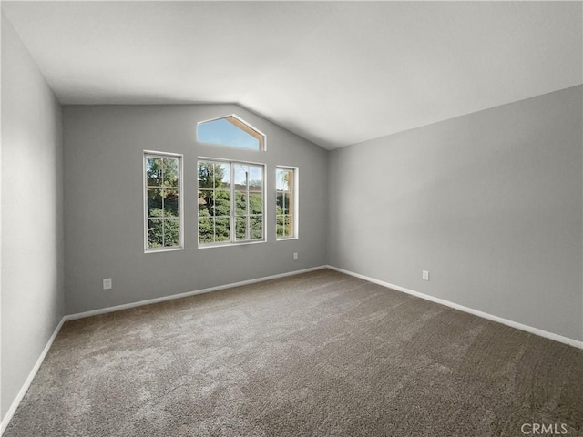 carpeted spare room featuring lofted ceiling