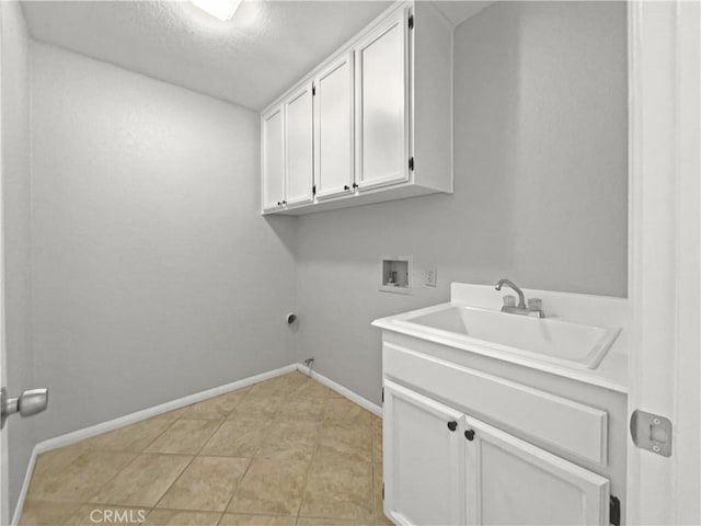 laundry area featuring sink, washer hookup, a textured ceiling, gas dryer hookup, and cabinets