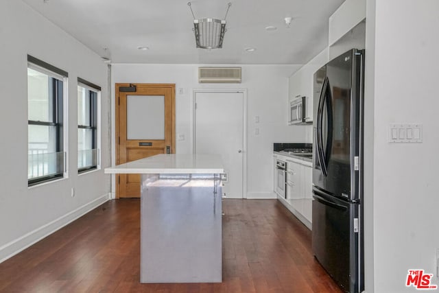 kitchen featuring white cabinets, a center island, appliances with stainless steel finishes, and dark hardwood / wood-style flooring