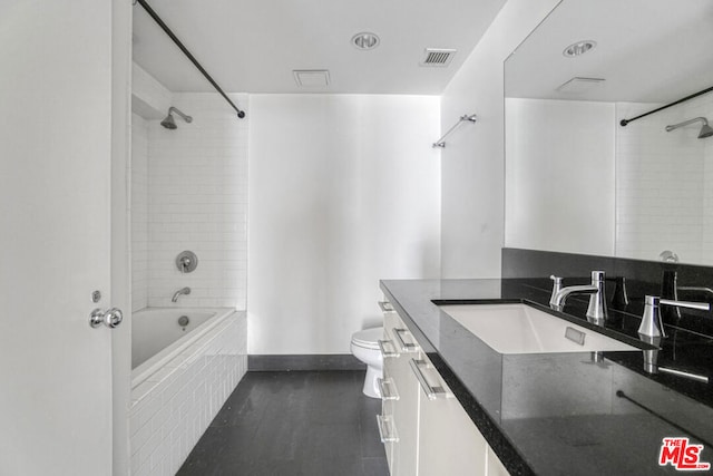 full bathroom featuring tiled shower / bath, vanity, and toilet